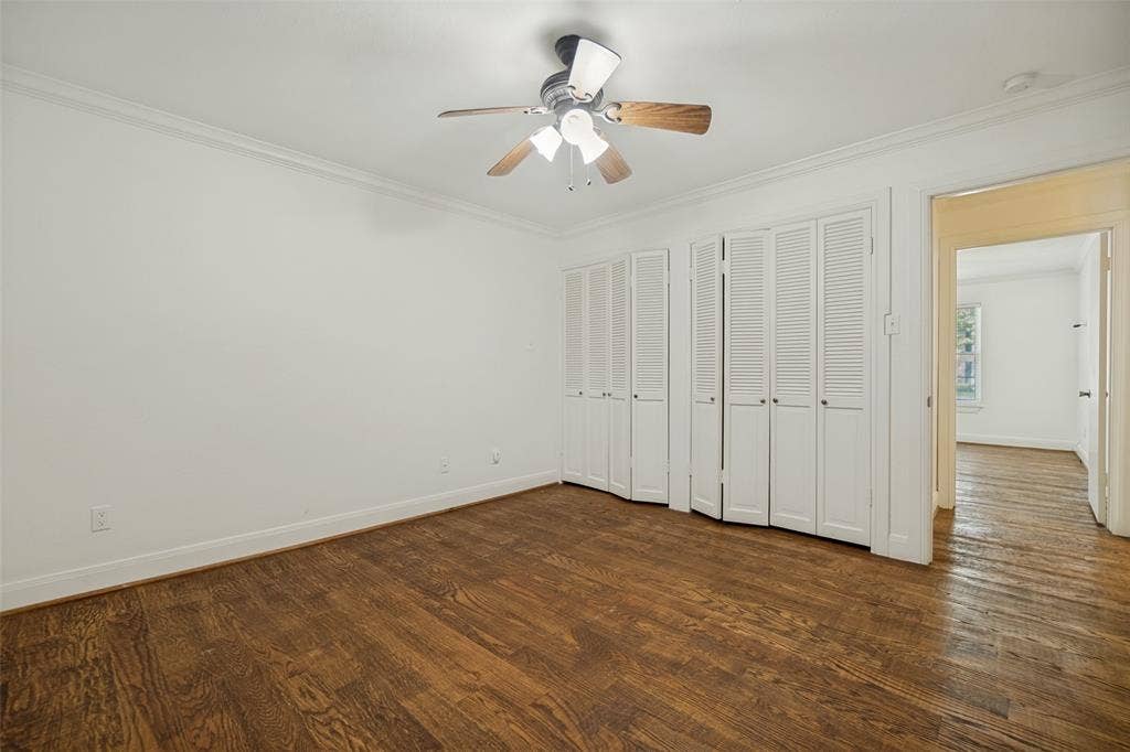 5818 E University Boulevard, #138, Dallas, TX 75206 Hardwood flooring, crown molding, white louvered bifold doors, and a ceiling fan with integrated lighting