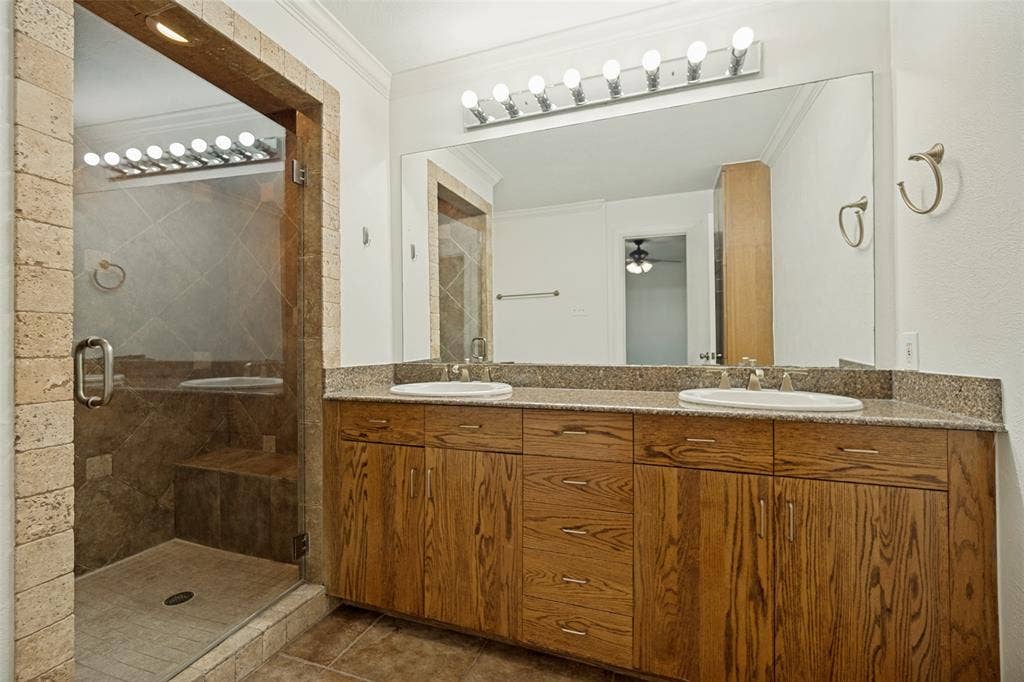 5818 E University Boulevard, #138, Dallas, TX 75206 Dual vanity with wood-finish cabinetry and stone-finish countertop