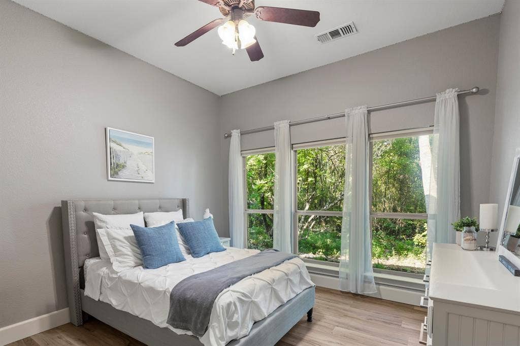 6810 Trinity Falls Parkway, McKinney, TX 75071 Vaulted ceiling with a ceiling fan, three pane windows, wood-finish flooring, and a large white dresser