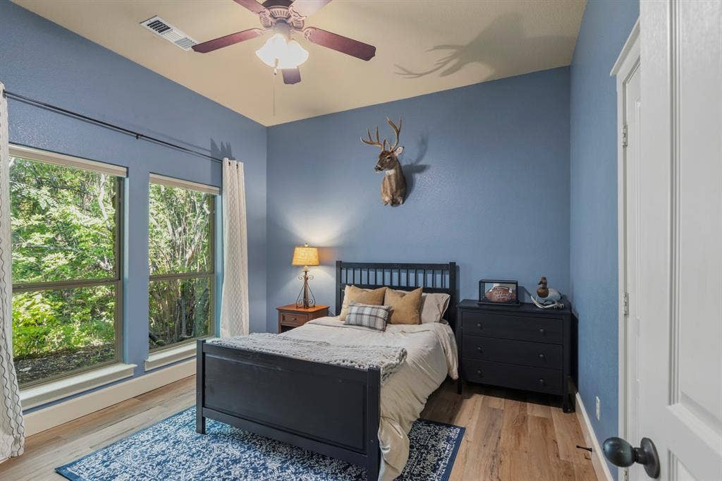 6810 Trinity Falls Parkway, McKinney, TX 75071 Expansive windows, wood-finish flooring, ceiling fan with integrated lighting, and a white paneled door
