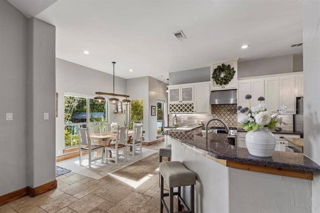 6810 Trinity Falls Parkway, McKinney, TX 75071 Kitchen featuring white cabinetry, stone countertops, a tile backsplash, and stainless steel appliances