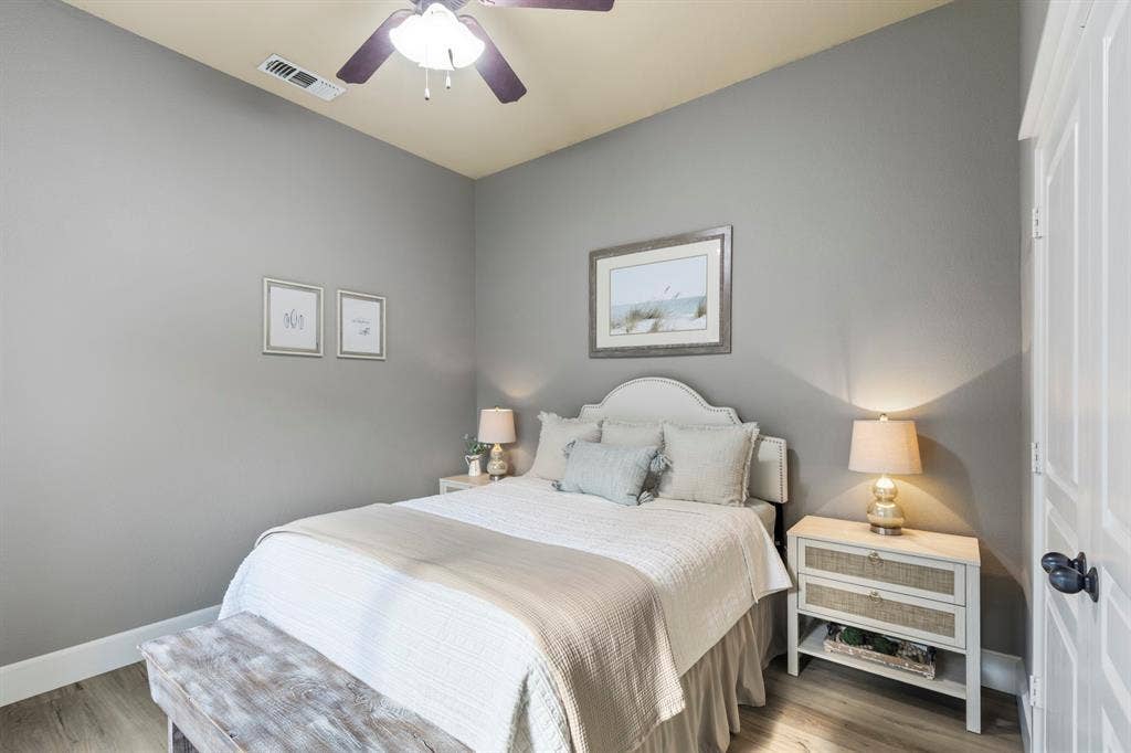 6810 Trinity Falls Parkway, McKinney, TX 75071 Wood-finish flooring, ceiling fan with integrated lighting, door with panel detailing, and a neutral color palette
