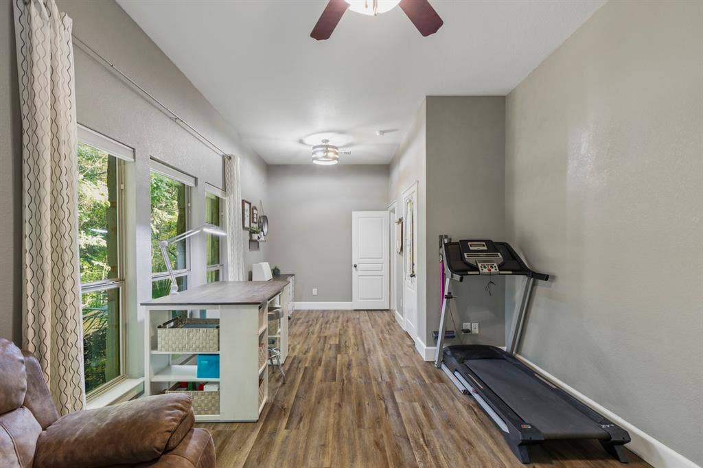 6810 Trinity Falls Parkway, McKinney, TX 75071 Spacious room featuring wood-finish flooring, multiple windows, and a ceiling fan