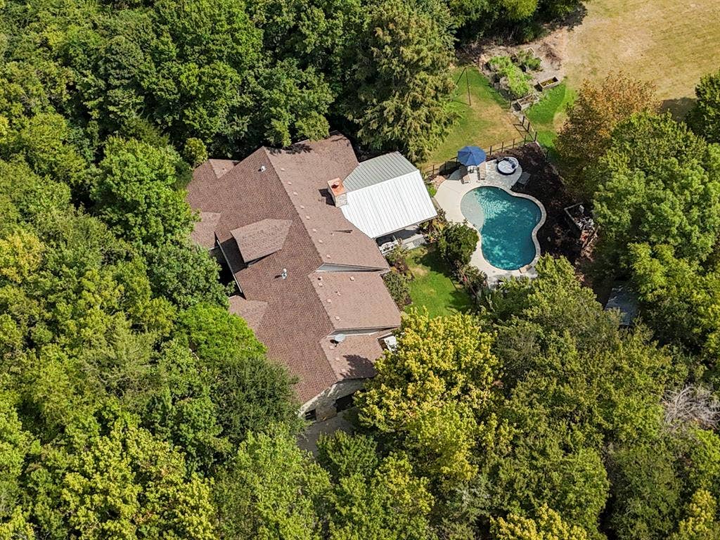6810 Trinity Falls Parkway, McKinney, TX 75071 Backyard with a freeform swimming pool, adjacent spa, and a covered patio structure