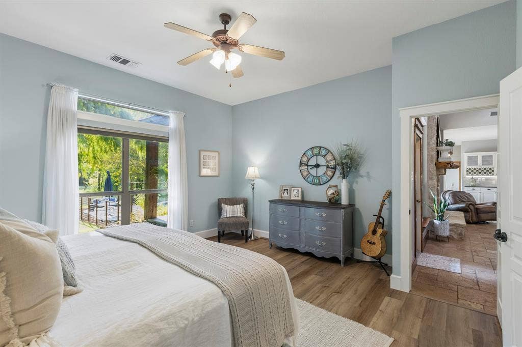 6810 Trinity Falls Parkway, McKinney, TX 75071 Wood-finish flooring, ceiling fan, and large windows with transom detail