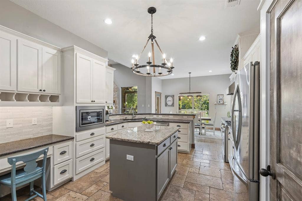 6810 Trinity Falls Parkway, McKinney, TX 75071 Well-appointed kitchen featuring granite countertops, a central island, recessed lighting, and integrated stainless steel appliances
