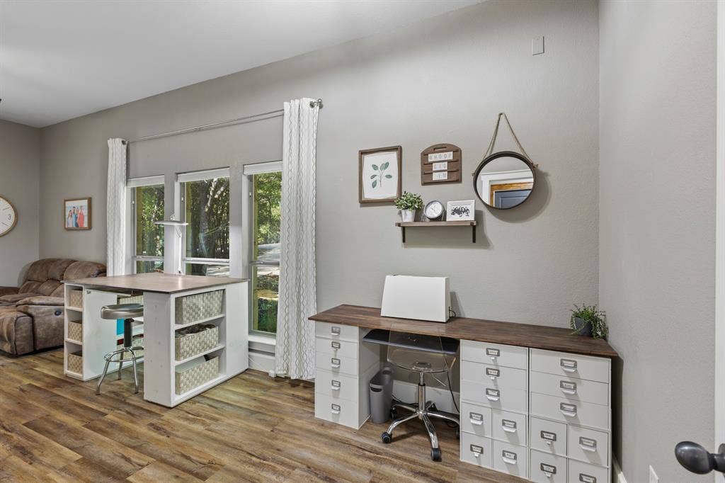 6810 Trinity Falls Parkway, McKinney, TX 75071 Wood-finish flooring, light grey wall paint, and multiple windows with white trim