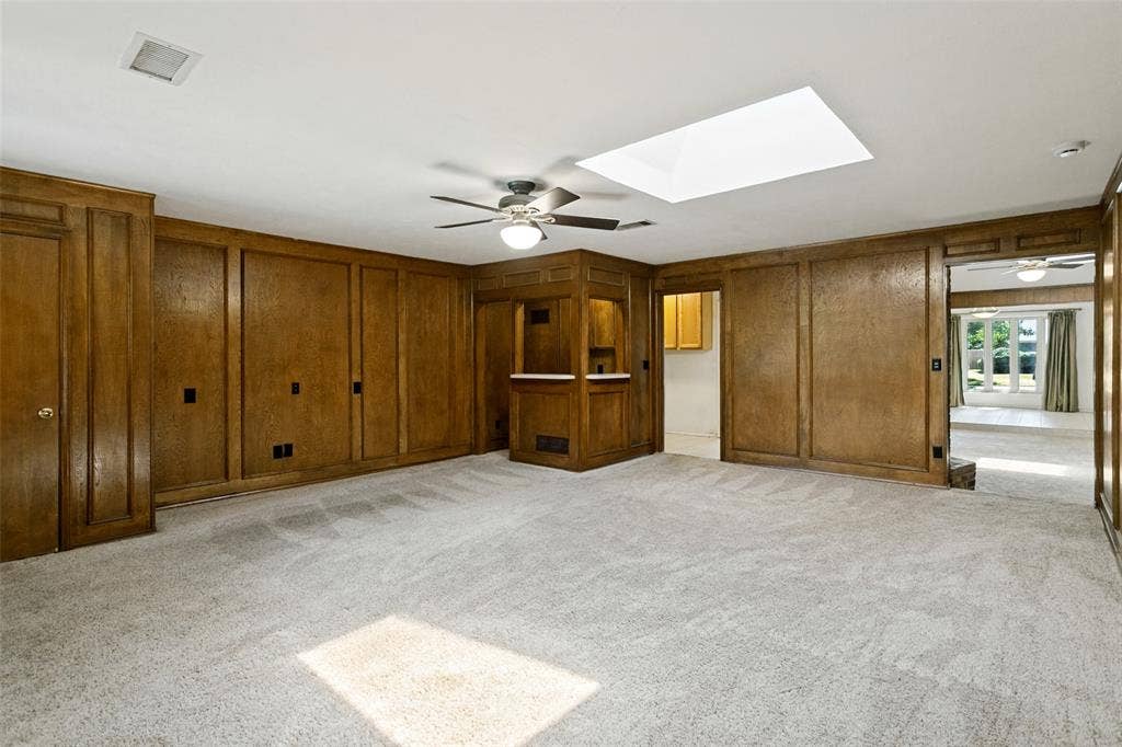 2717 Pinehurst Drive, Plano, TX 75075 Warm wood paneling, built-in cabinetry, and a skylight