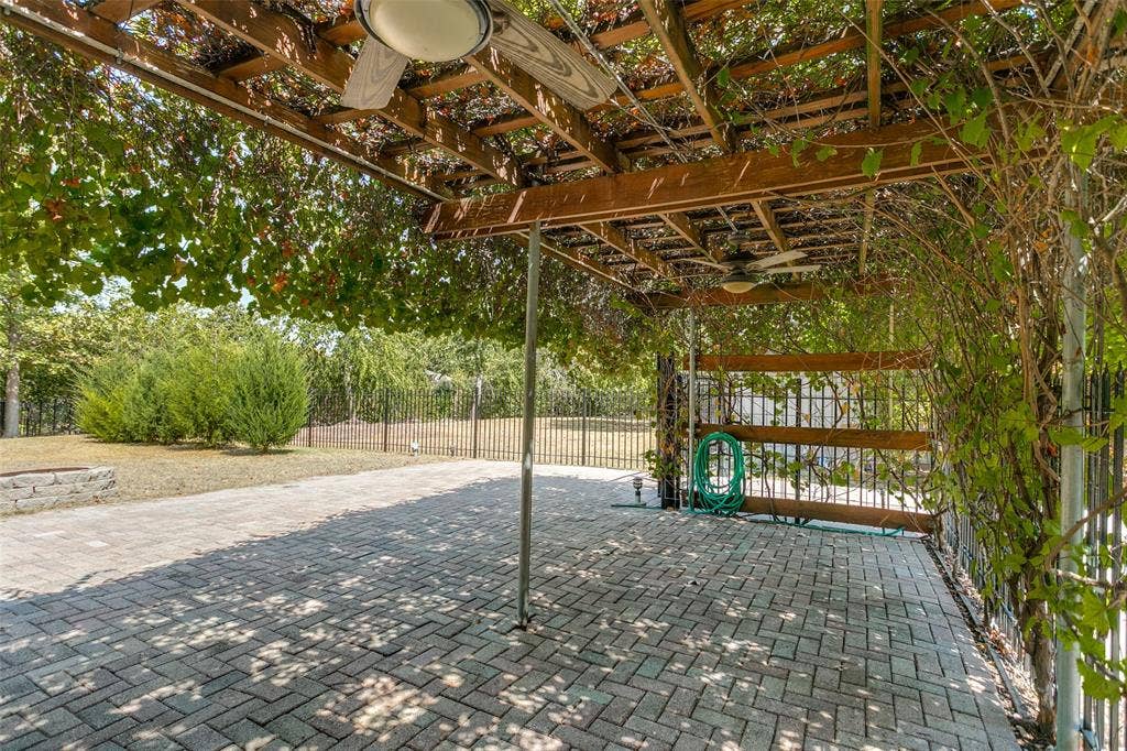 2717 Pinehurst Drive, Plano, TX 75075 Patio featuring a wood pergola with integrated ceiling fans, brick paver flooring, and perimeter fencing