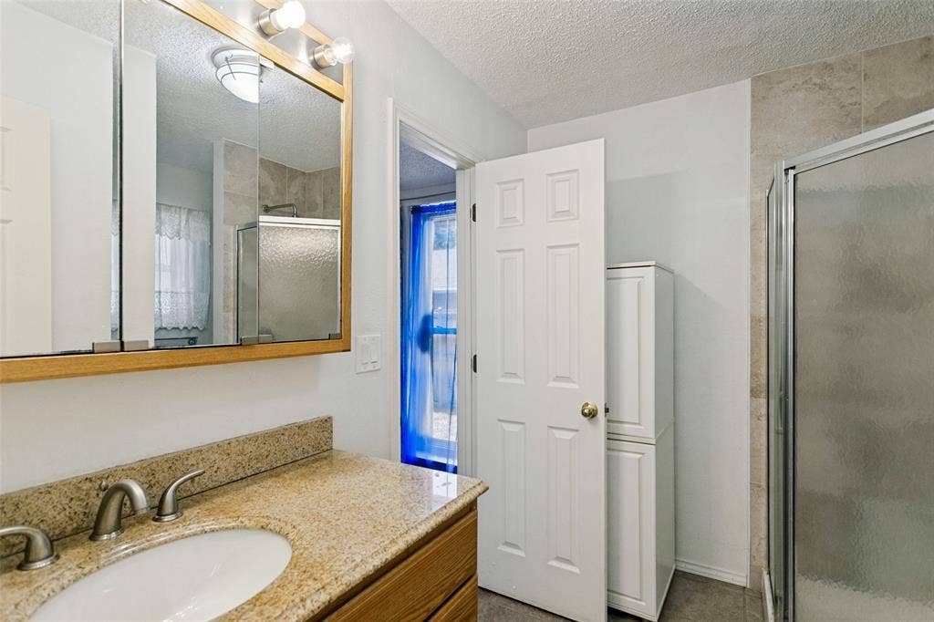 2717 Pinehurst Drive, Plano, TX 75075 Vanity with an oval basin, dual-handle faucet, and granite-style countertop
