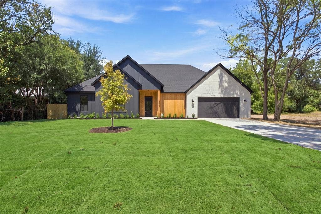 3023 Mallory Drive, Dallas, TX 75216 Modern exterior with a combination of dark siding, light-colored stucco, and wood paneling