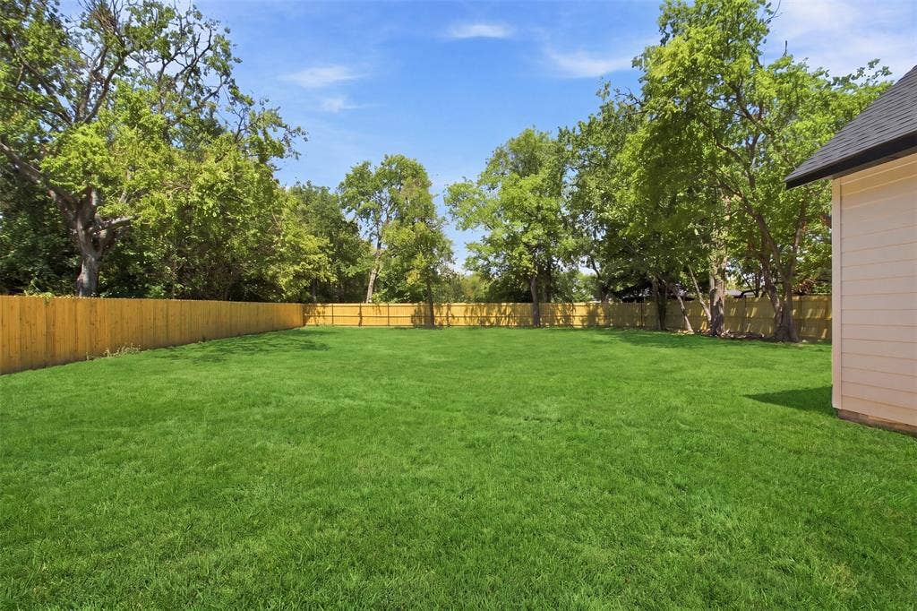 3023 Mallory Drive, Dallas, TX 75216 Expansive rear yard featuring a privacy fence and mature perimeter trees