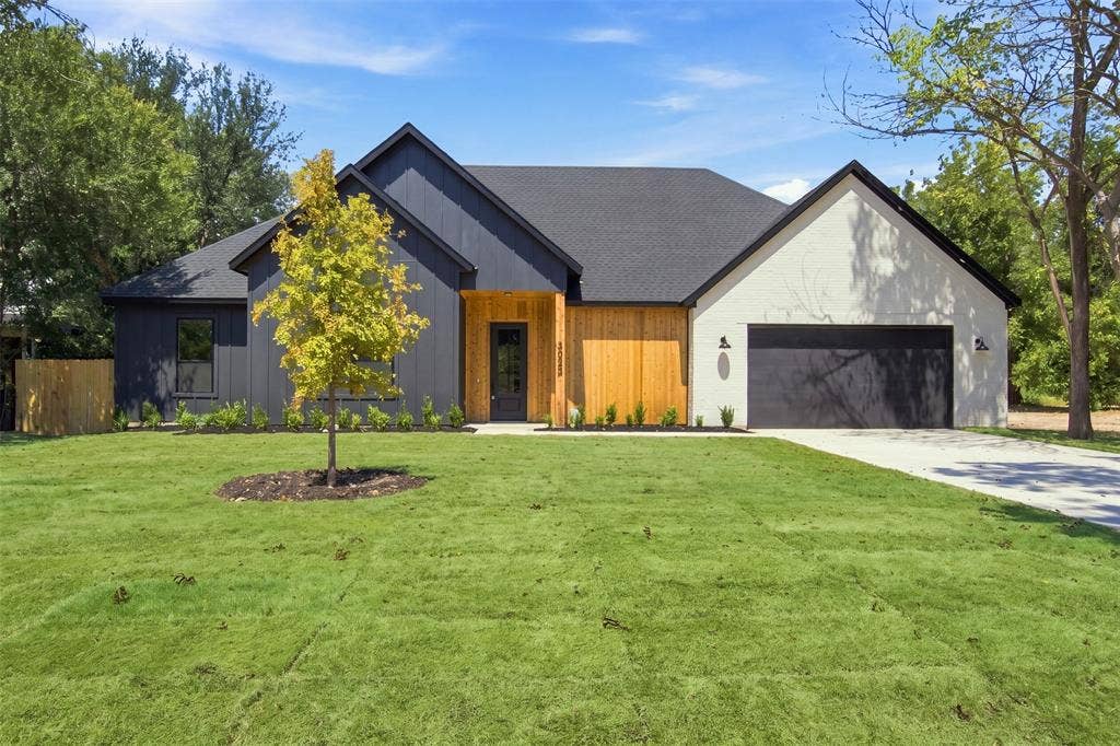 3023 Mallory Drive, Dallas, TX 75216 Modern exterior featuring dark vertical siding, light-toned brick, and natural wood accents