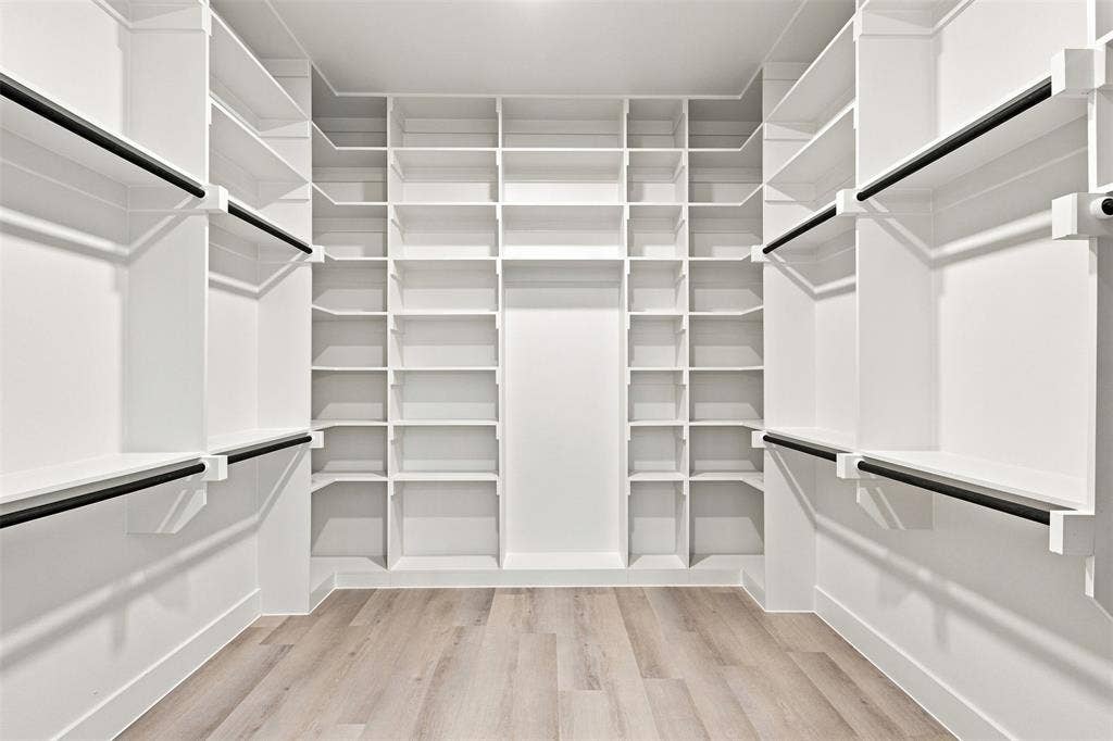 3023 Mallory Drive, Dallas, TX 75216 Built-in closet system with extensive shelving, multiple hanging rods, and wood-finish flooring