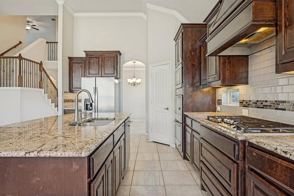 801 Feathering Way, Plano, TX 75074 Kitchen featuring granite countertops, wood cabinetry, stainless steel appliances, and a gas cooktop