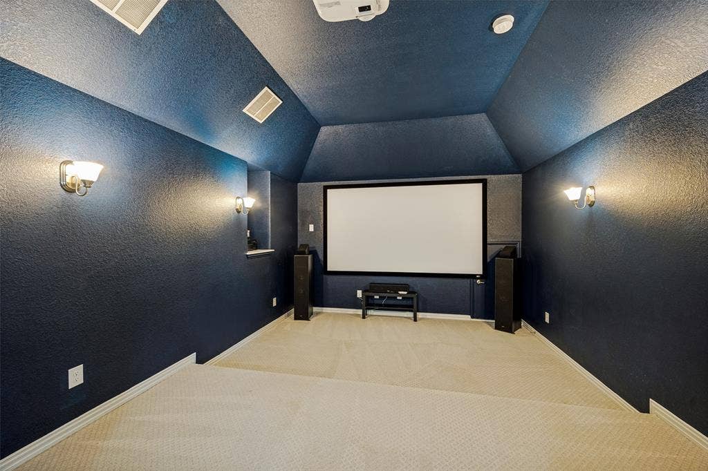 801 Feathering Way, Plano, TX 75074 Media room with sloped ceiling, built-in projector screen, and sconce lighting