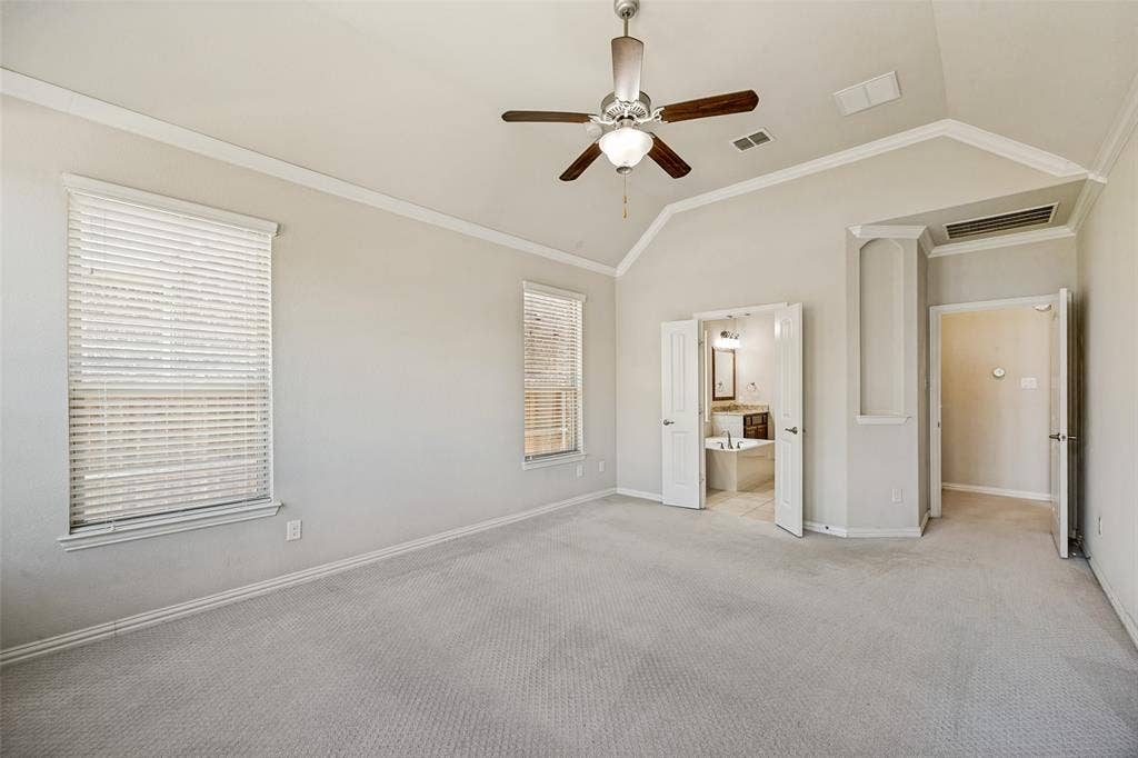 801 Feathering Way, Plano, TX 75074 Vaulted ceiling with crown molding, two windows with blinds, a ceiling fan with light fixture, and carpeted flooring