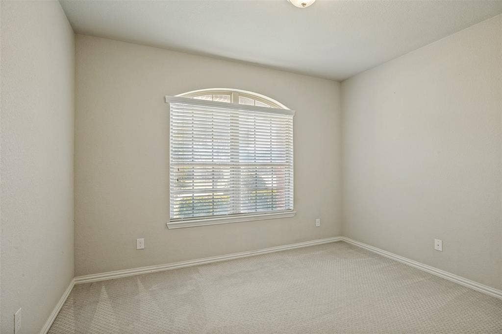 801 Feathering Way, Plano, TX 75074 Arched window with blinds, light gray wall paint, and gray carpeting