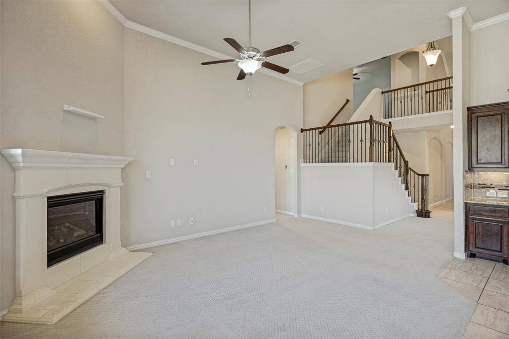 801 Feathering Way, Plano, TX 75074 Great room with a corner fireplace, vaulted ceiling, and ceiling fan
