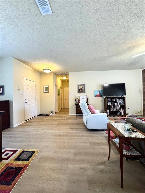 5512 Vineyard Lane, McKinney, TX 75070 Expansive room with wood-finish flooring, recessed ceiling lighting, and a neutral wall palette