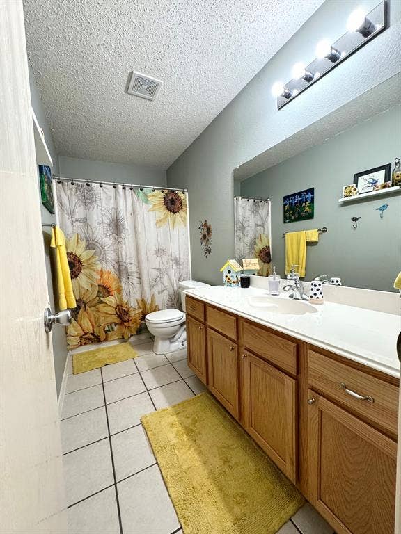 5512 Vineyard Lane, McKinney, TX 75070 Bathroom featuring a wood-finish vanity with a white countertop and integrated sink, a large wall-mounted mirror, and tile flooring