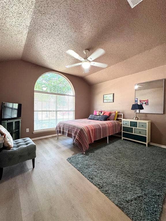 5512 Vineyard Lane, McKinney, TX 75070 Vaulted ceiling with a ceiling fan, arched window with horizontal blinds, light wood-finish flooring, and painted walls