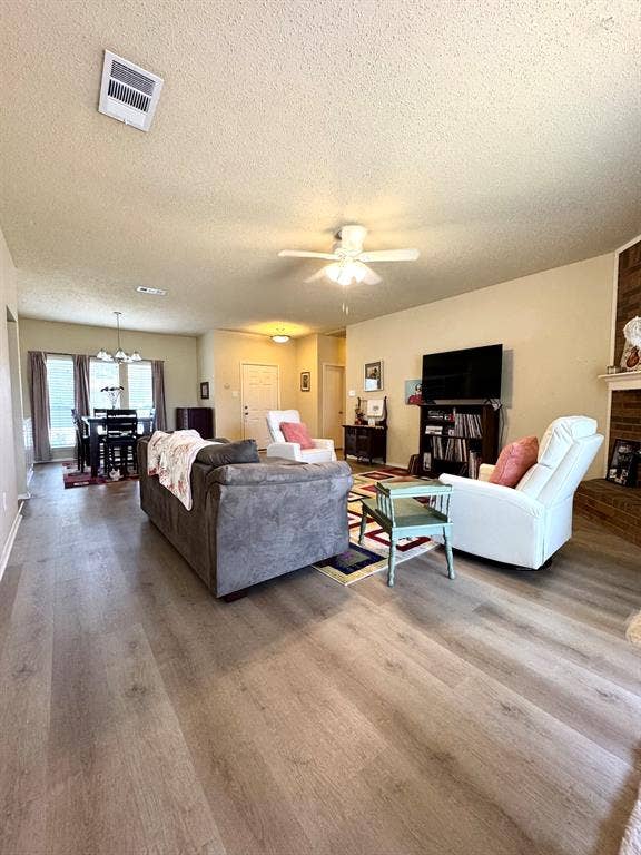 5512 Vineyard Lane, McKinney, TX 75070 Wood-finish flooring throughout, ceiling fan with integrated lighting, brick-clad fireplace, and recessed lighting