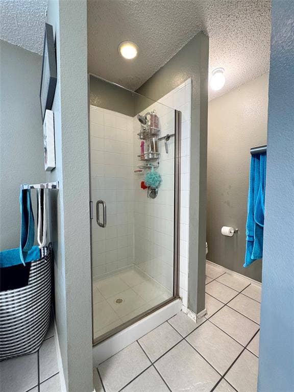 5512 Vineyard Lane, McKinney, TX 75070 Glass-enclosed shower with white tiled walls and a white shower pan