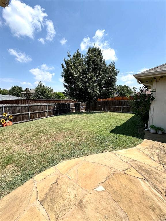 5512 Vineyard Lane, McKinney, TX 75070 Expansive backyard featuring a mature tree, wood privacy fencing, and a flagstone patio