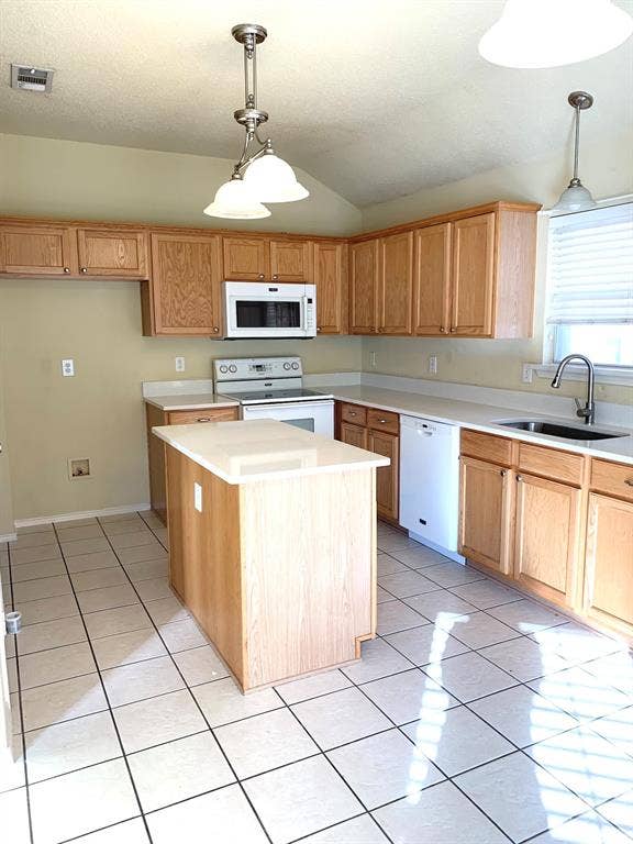 5512 Vineyard Lane, McKinney, TX 75070 Kitchen featuring wood cabinetry, white appliances, a center island with a light-toned countertop, and tile flooring
