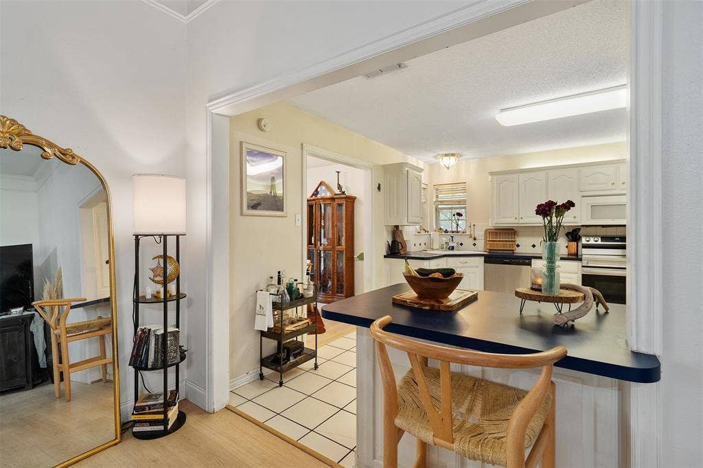 310 Linda Lane, Lindale, TX 75771 Kitchen featuring white cabinetry, stainless steel appliances, a built-in oven, and a breakfast bar with a solid surface countertop