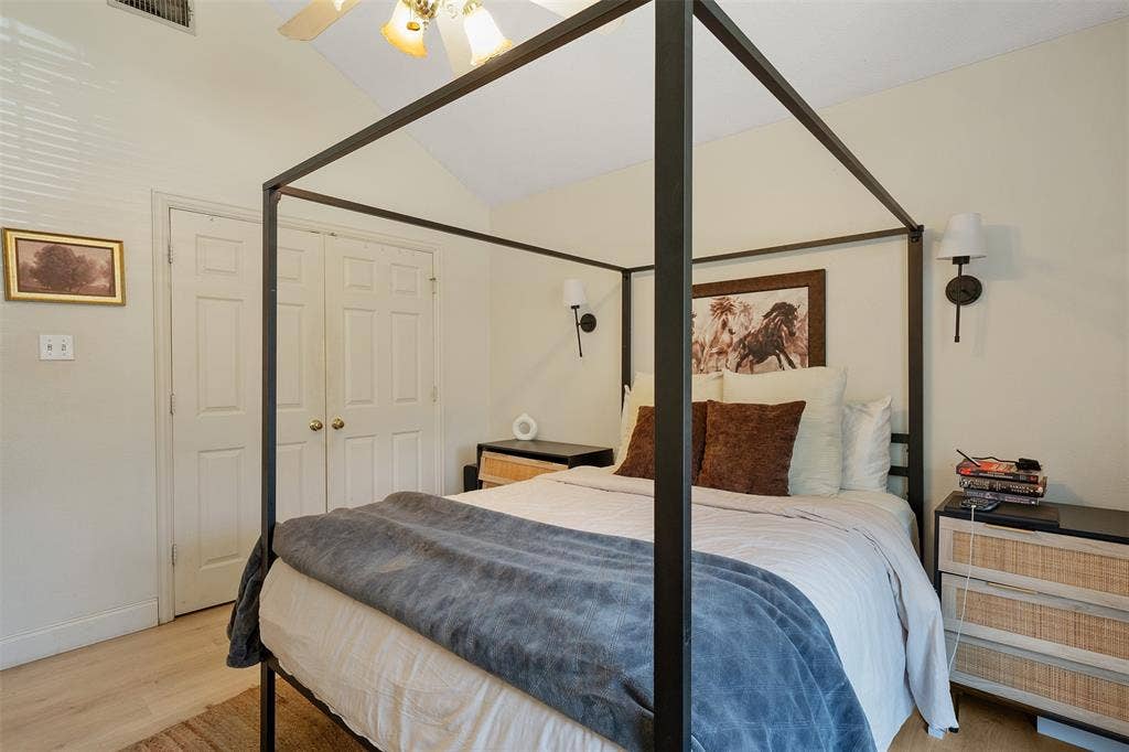 310 Linda Lane, Lindale, TX 75771 Vaulted ceiling with a ceiling fan, dual bi-fold doors, wood-finish flooring, and wall-mounted sconces