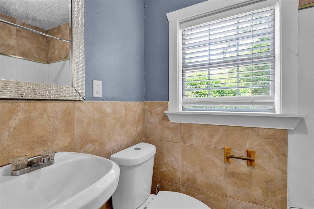 3572 State Highway 110 N, Tyler, TX 75704 Bathroom featuring a pedestal sink, toilet, and a window with blinds