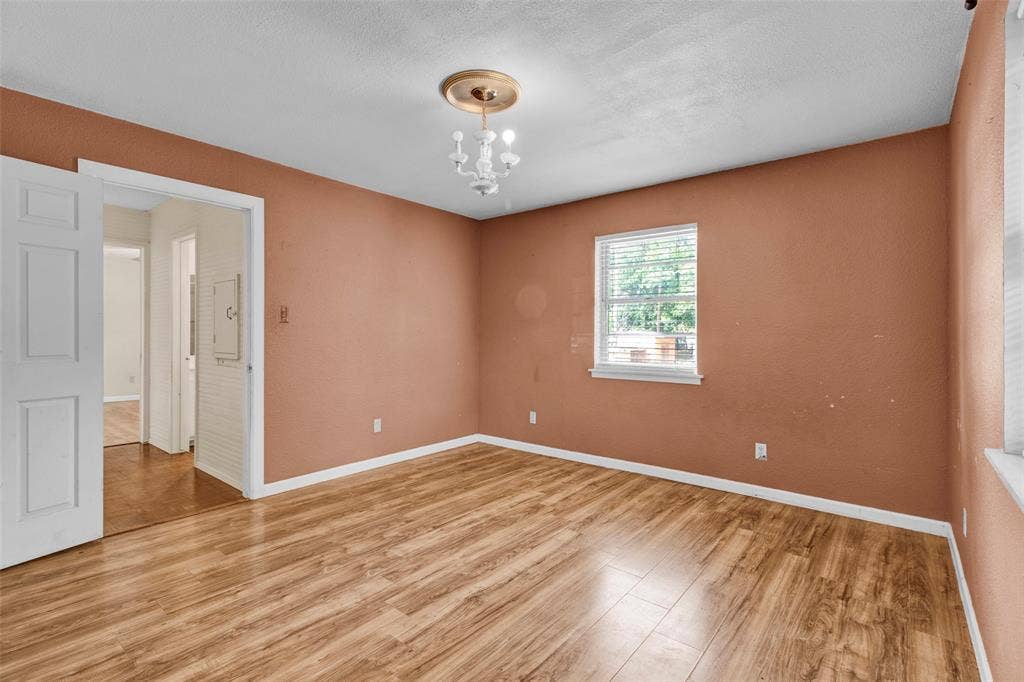 3572 State Highway 110 N, Tyler, TX 75704 Wood-finish flooring, single window with blinds, white trim throughout, and a decorative ceiling light fixture
