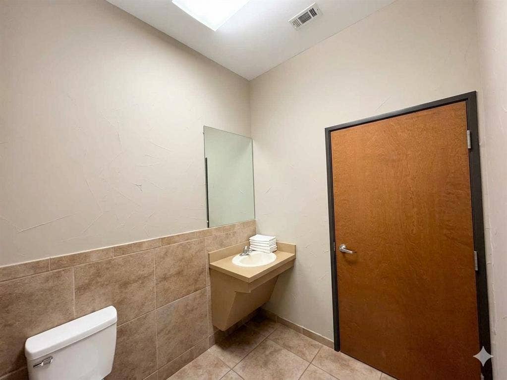 4512 Legacy Drive, #100, Plano, TX 75024 Recessed ceiling lighting, wall-mounted mirror, ceramic tile flooring, and a wall-mounted vanity with integrated sink