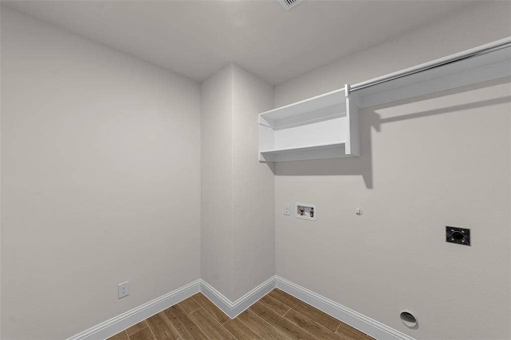 Wood-finish flooring, white built-in shelving, white trim, and light-toned walls