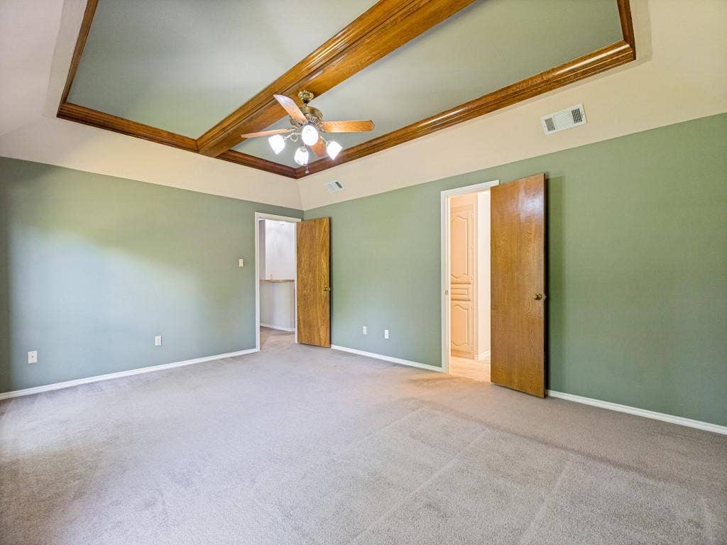 26 Lago Vista W, Wylie, TX 75098 Tray ceiling with wood-finish beams, ceiling fan, looking into primary bathroom.