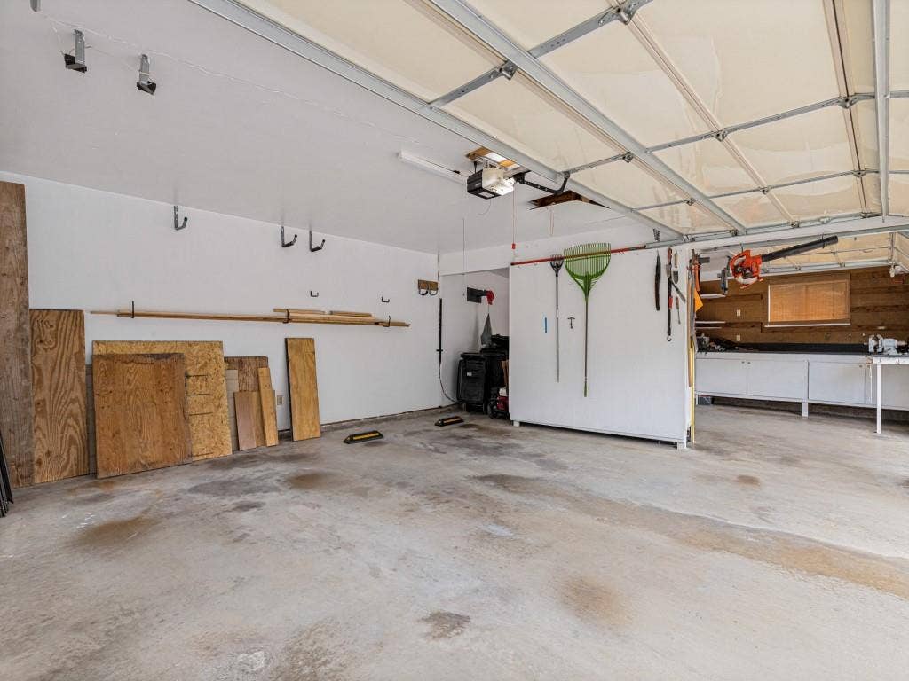 26 Lago Vista W, Wylie, TX 75098 Spacious 3 car garage with concrete flooring, overhead garage door, built-in cabinetry, and work bench in 3rd bay.