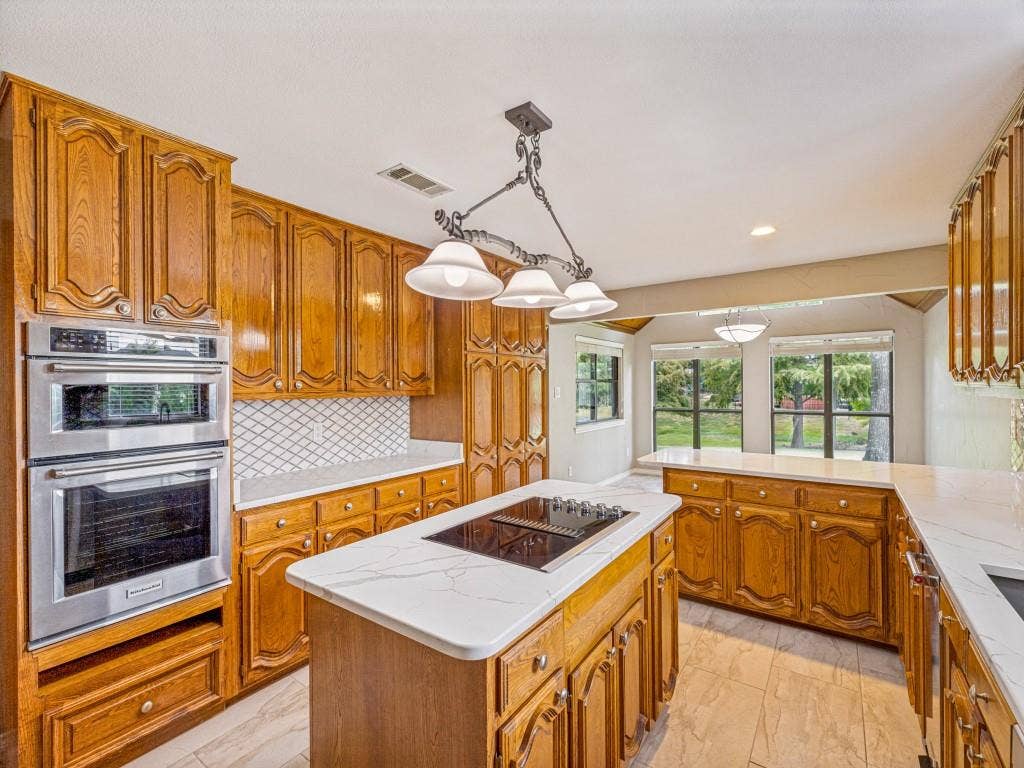 26 Lago Vista W, Wylie, TX 75098 Kitchen featuring wood cabinetry, Quartz counters, a tiled backsplash, and stainless steel microwave, oven and trash compactor