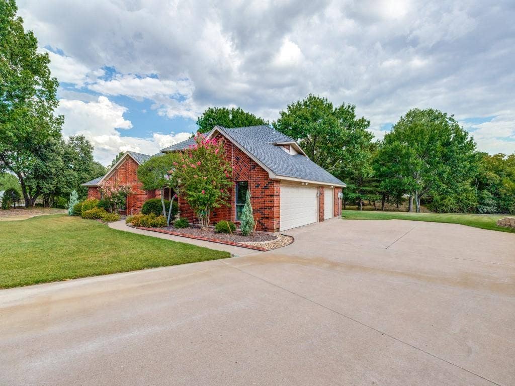 26 Lago Vista W, Wylie, TX 75098 Brick exterior with a gabled roof and 3 car garage