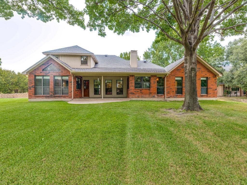 26 Lago Vista W, Wylie, TX 75098 Expansive rear lawn with mature trees and a covered patio