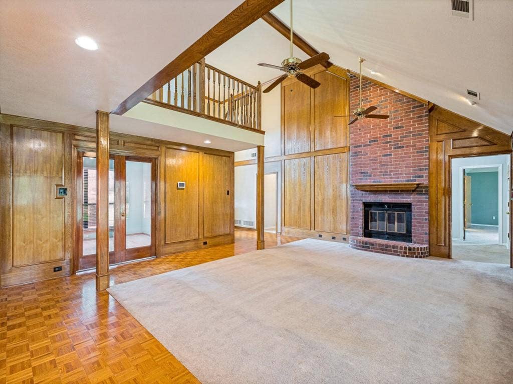 26 Lago Vista W, Wylie, TX 75098 Vaulted ceiling, brick fireplace, wood paneling, and a second-story interior balcony