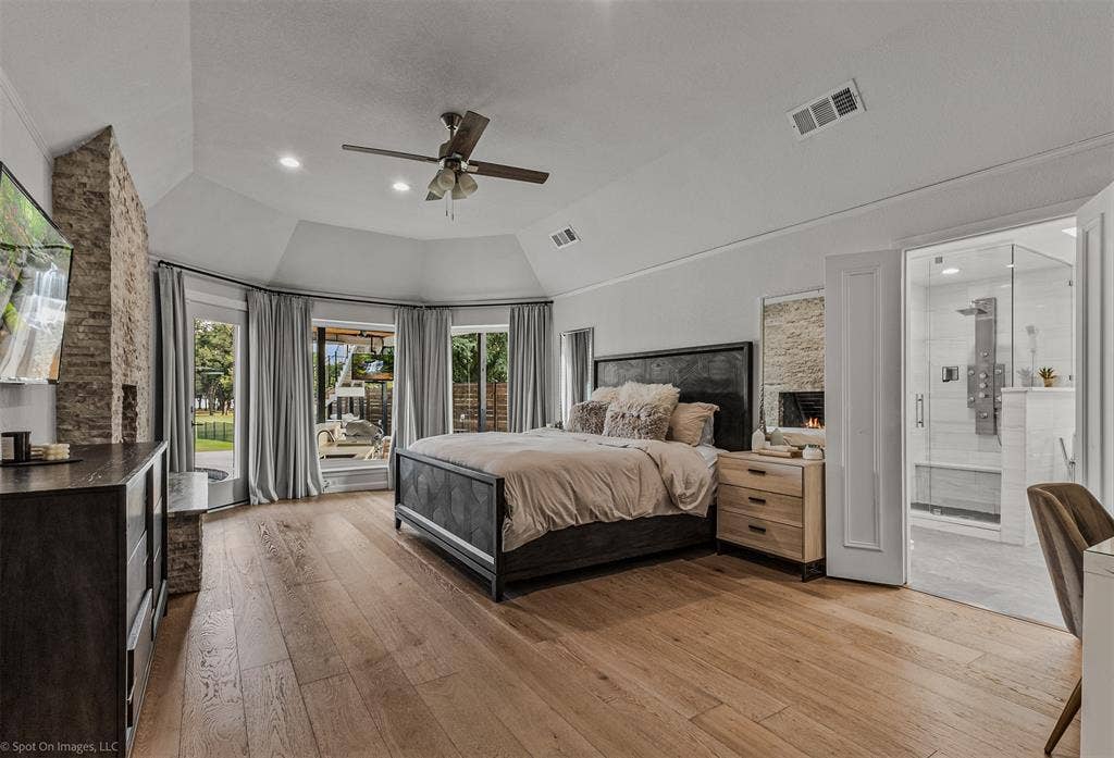 28 Victoria Drive, Rowlett, TX 75088 Wood-finish flooring, vaulted ceiling, recessed lighting, ceiling fan, and a built-in fireplace with stone surround