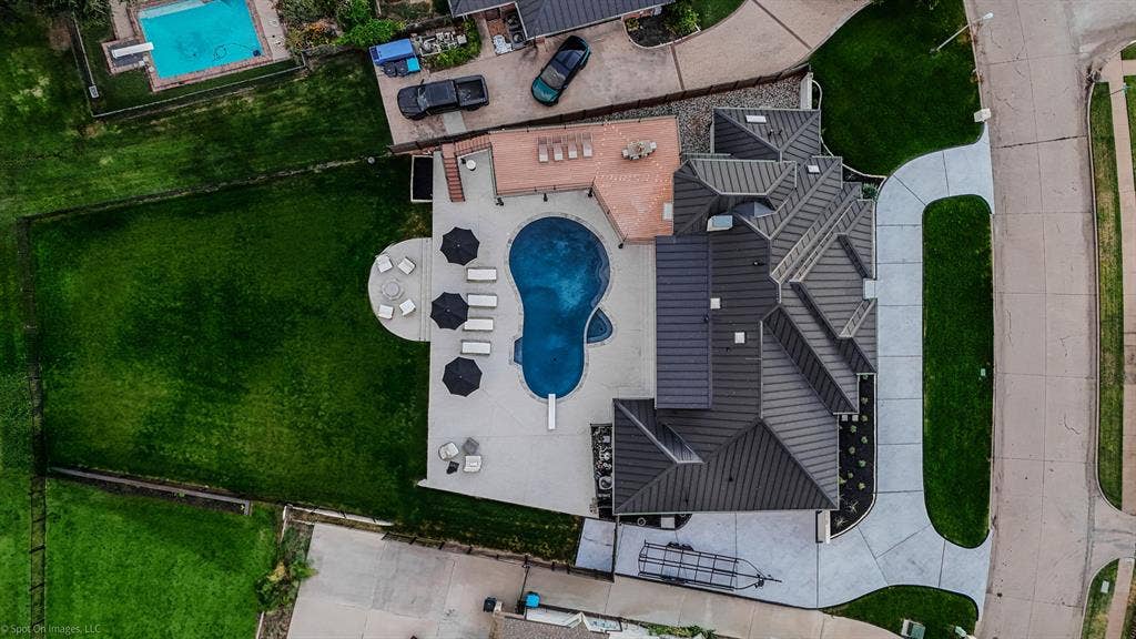 28 Victoria Drive, Rowlett, TX 75088 Custom swimming pool with integrated diving board, expansive concrete patio, outdoor decking, and a large manicured lawn