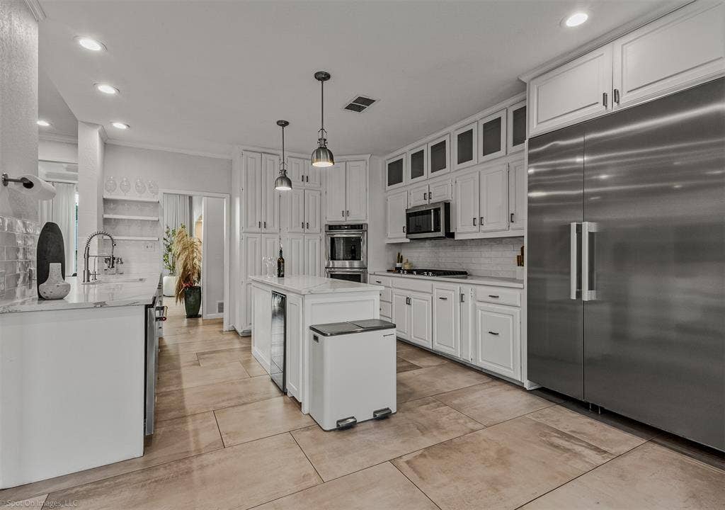 28 Victoria Drive, Rowlett, TX 75088 Spacious kitchen featuring white cabinetry, stainless steel appliances, a large center island, tile flooring, and recessed lighting