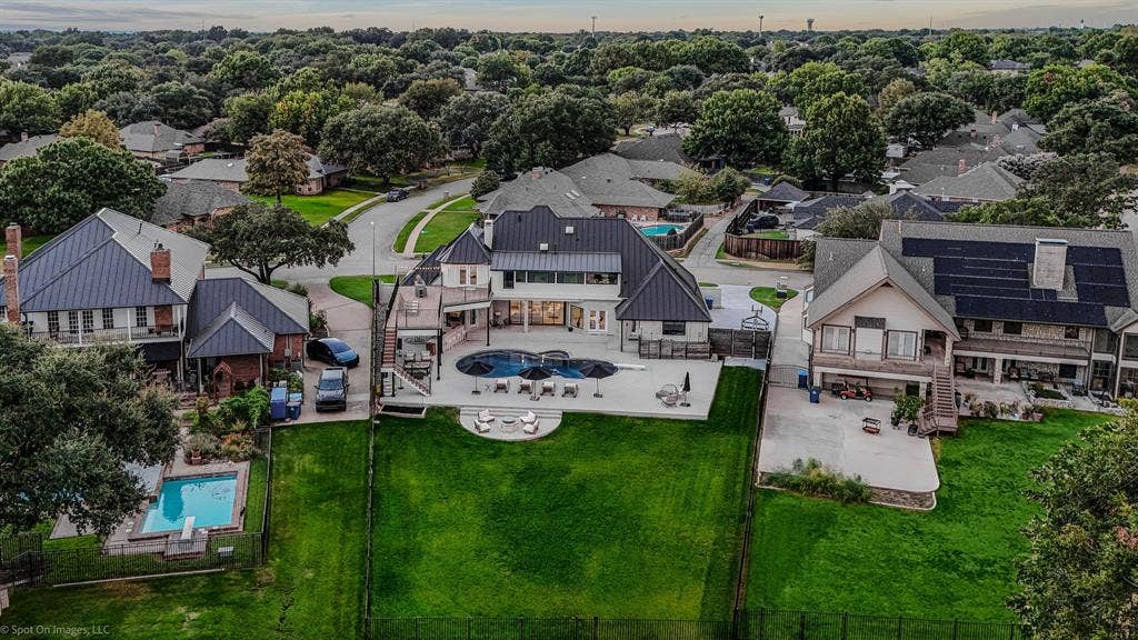 28 Victoria Drive, Rowlett, TX 75088 Contemporary residence featuring a private pool with expansive decking, a large manicured lawn, and multiple outdoor patios