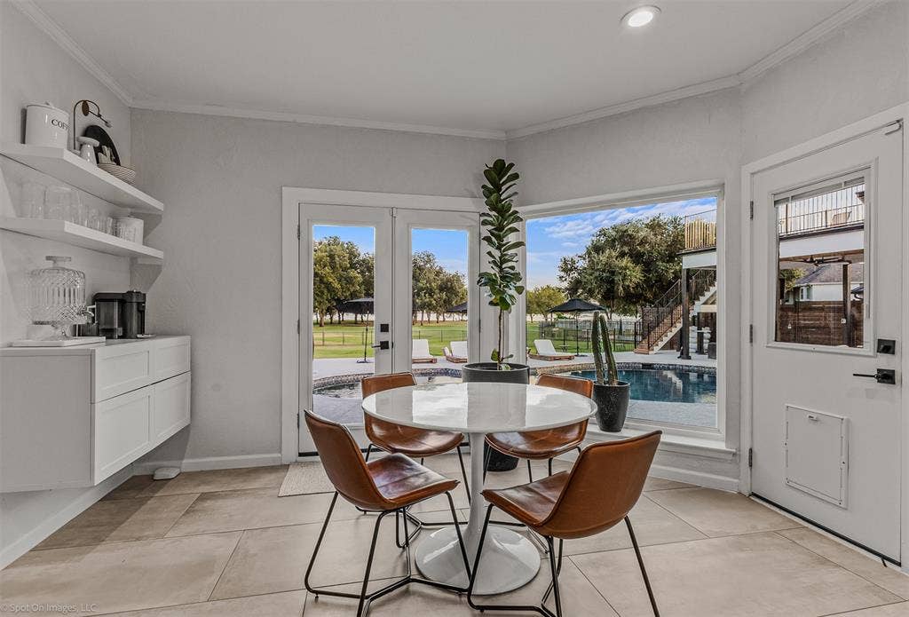 28 Victoria Drive, Rowlett, TX 75088 Built-in floating cabinetry with open shelving, tile flooring, corner window, and double French doors opening to a swimming pool