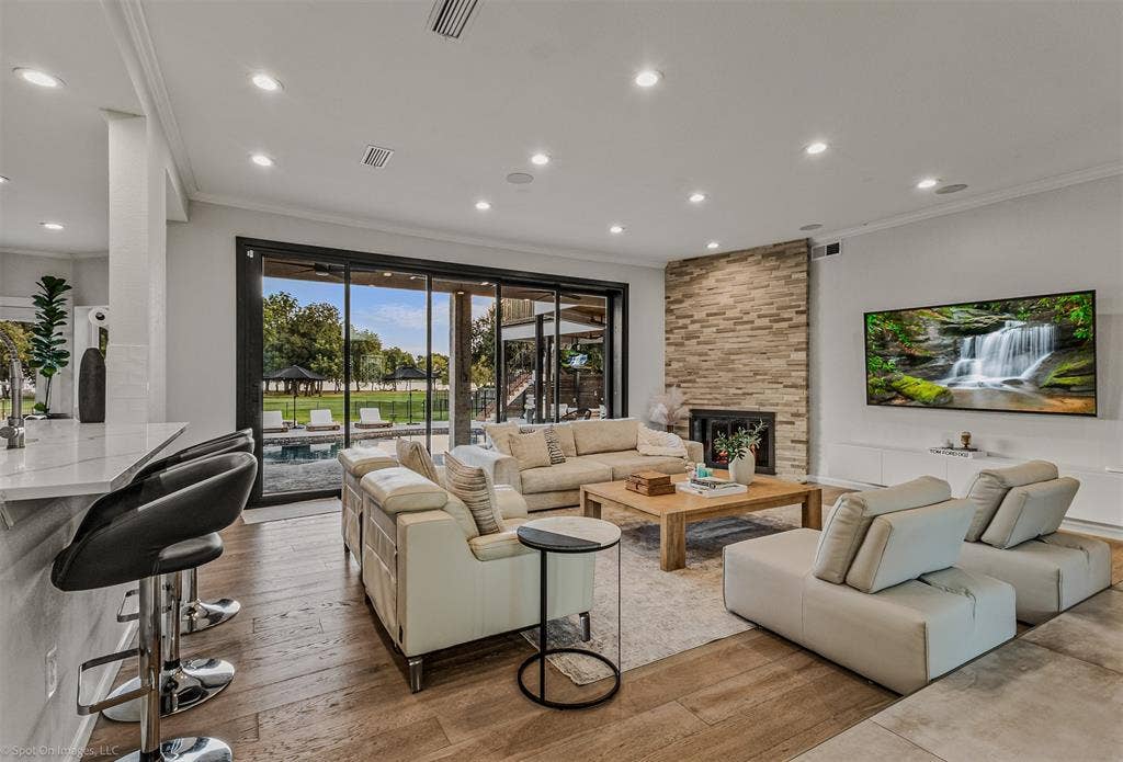 28 Victoria Drive, Rowlett, TX 75088 Spacious living area featuring wood-finish flooring, a stone-clad fireplace, and recessed lighting