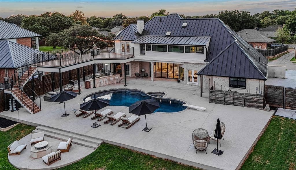 28 Victoria Drive, Rowlett, TX 75088 Expansive backyard featuring a custom pool, tiered concrete patio, and a dedicated fire pit area