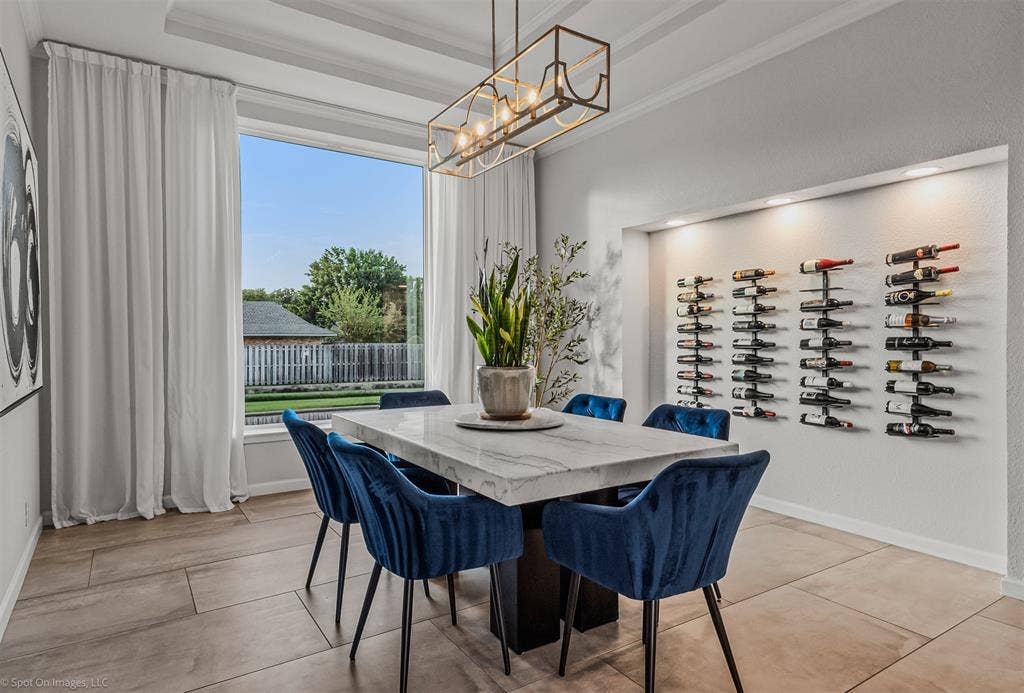 28 Victoria Drive, Rowlett, TX 75088 Tray ceiling with a linear chandelier, built-in wine storage with accent lighting, large picture window, and wide-plank tile flooring